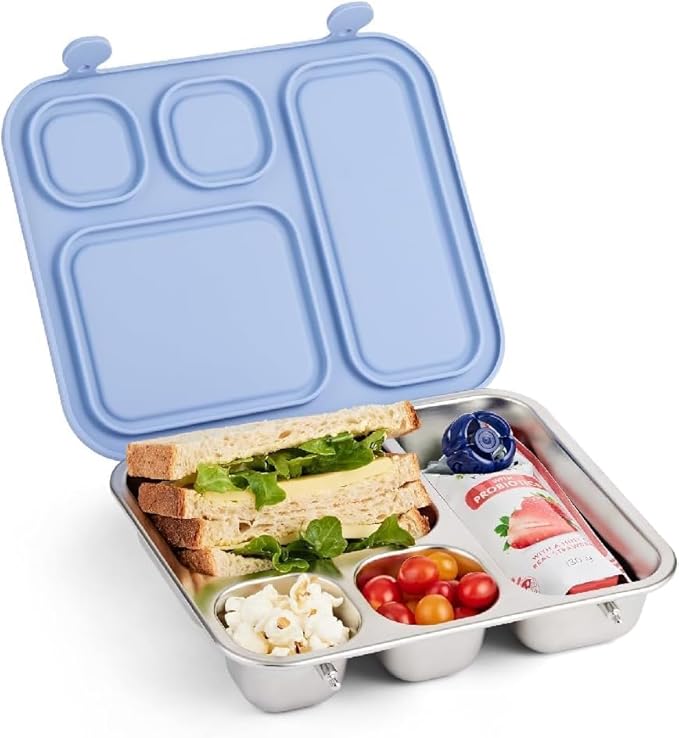 A stainless steel lunchbox with a light blue lid, containing a sandwich with lettuce, a pouch of fruit beverage, cherry tomatoes, and a portion of popcorn.