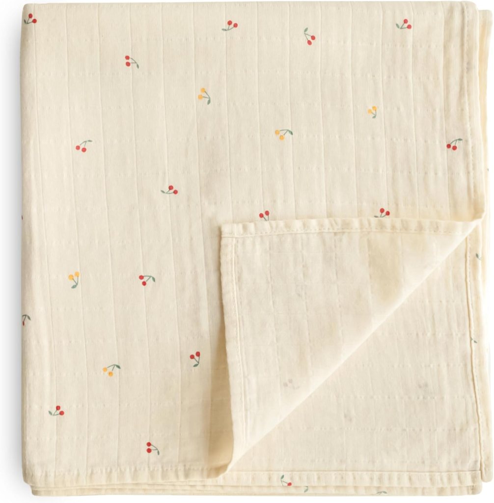 A cream-colored blanket with a subtle striped texture, adorned with small floral patterns in red and yellow.