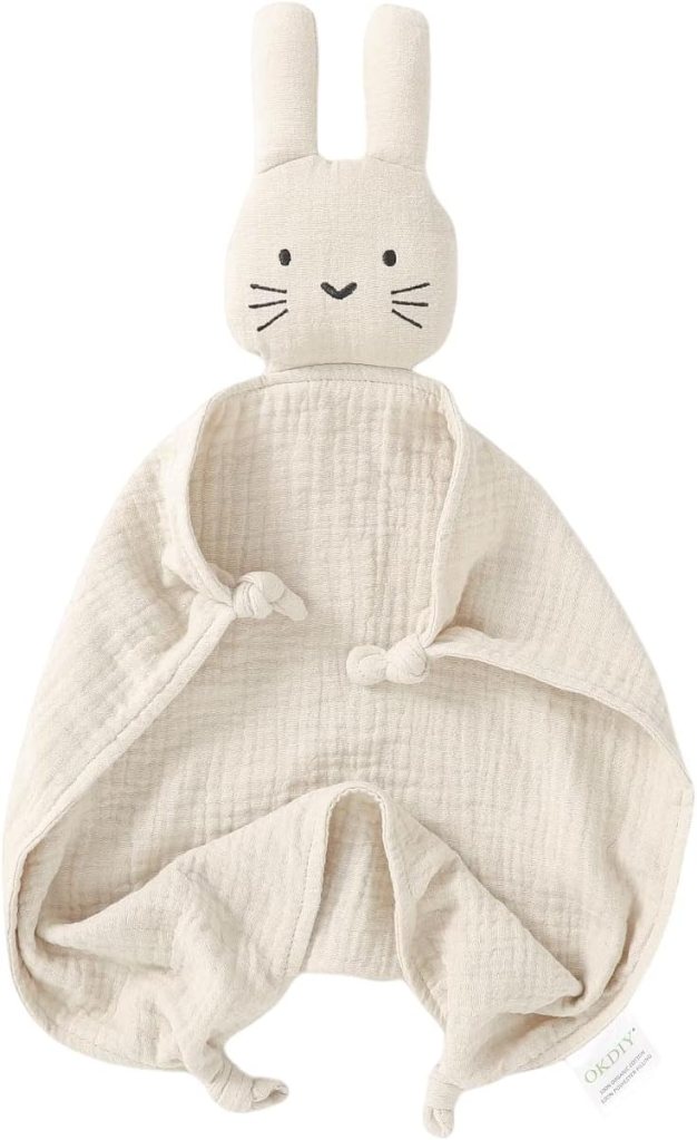 A soft, beige baby cuddle toy featuring a rabbit head with ears and a simple facial expression, attached to a triangular shaped blanket.